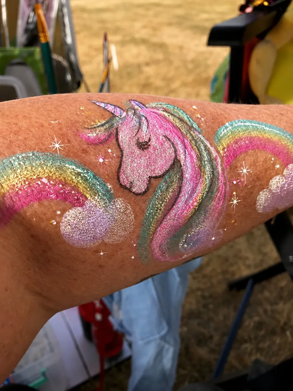 Pink unicorn and rainbow glitter art on an arm